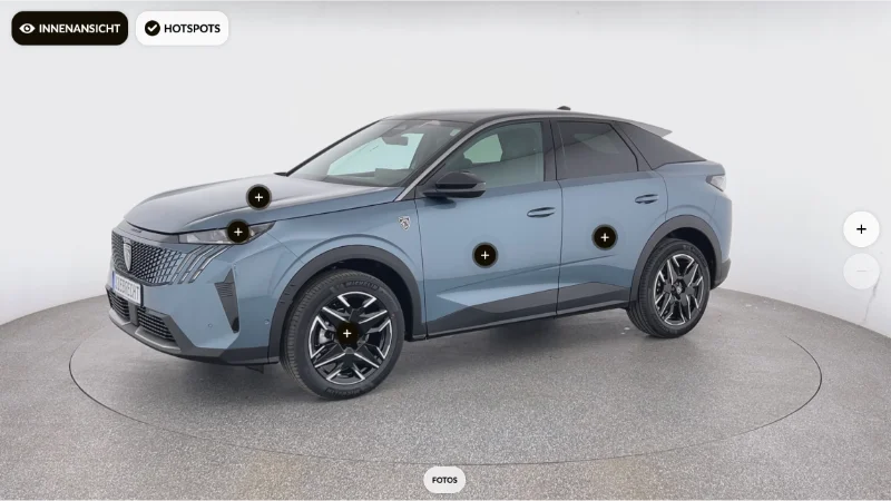 Ein moderner, blauer SUV in einem Showroom. Das Fahrzeug steht auf einem drehbaren Podest, wodurch alle Seiten des Wagens sichtbar sind. Auf dem Bild sind interaktive Punkte markiert, die m&ouml;glicherweise detaillierte Informationen &uuml;ber verschiedene Teile des Autos bieten, wie zum Beispiel die R&auml;der, T&uuml;ren und das Logo. Im Hintergrund ist der