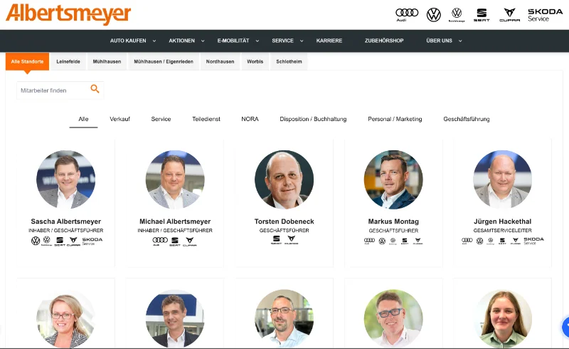 Das Bild zeigt eine Webseite des Automobilunternehmens Albertsmeyer. Oben befinden sich das Firmenlogo und verschiedene Navigationslinks wie Auto kaufen, Aktionen, E-Mobilität und Service. Unterhalb davon sind Filteroptionen zur Auswahl von Standorten und Abteilungen. Darunter werden Profilbilder von sechs