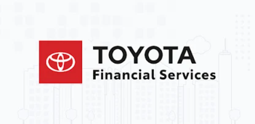 Das Bild zeigt das Logo von Toyota Financial Services. Links befindet sich ein rotes Quadrat mit dem Toyota-Emblem, rechts davon steht der Text TOYOTA Financial Services in schwarzer Schrift. Der Hintergrund ist hellgrau mit schematischen Umrissen von Gebäuden.